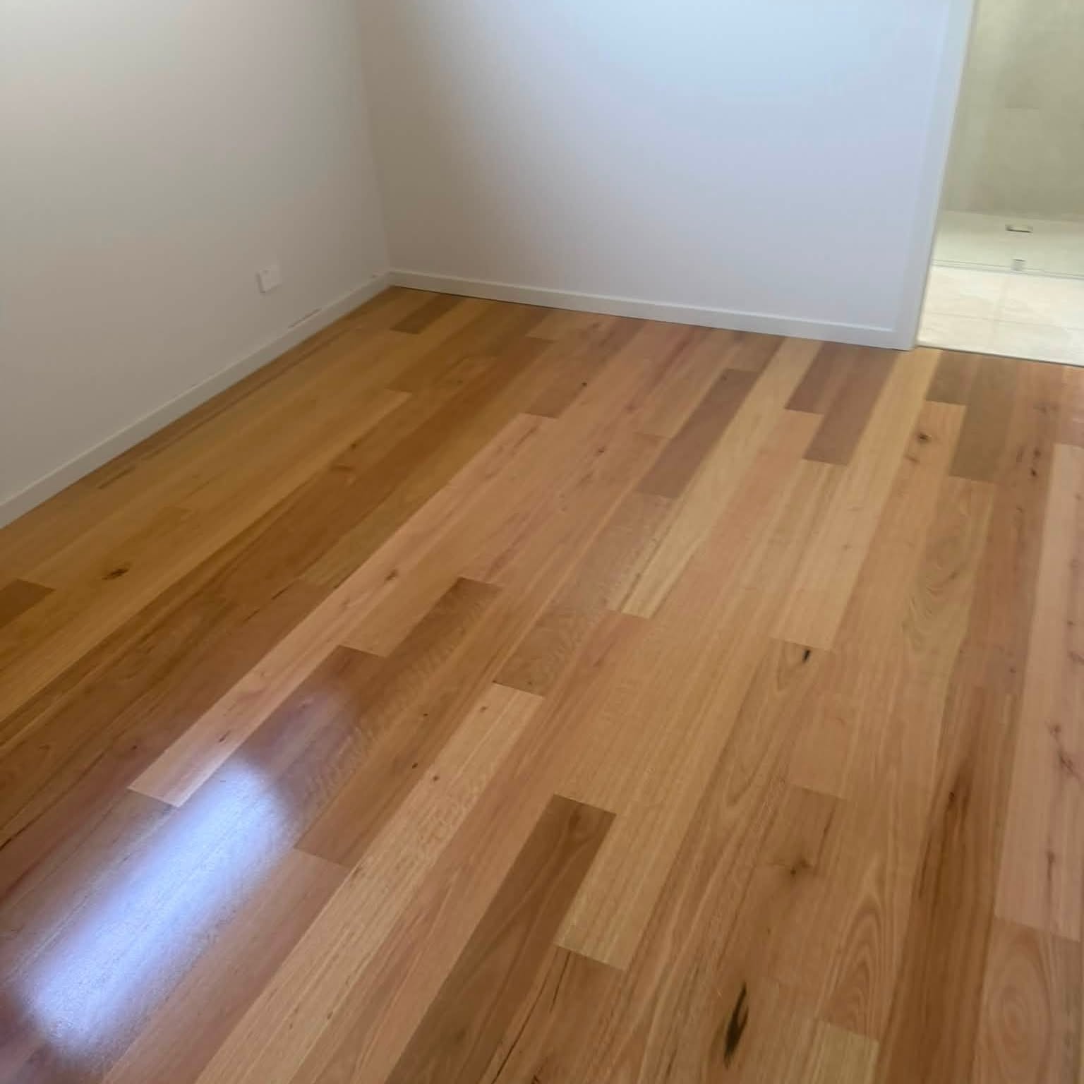 Freshly laid timber floor in an empty room after water damage repairs