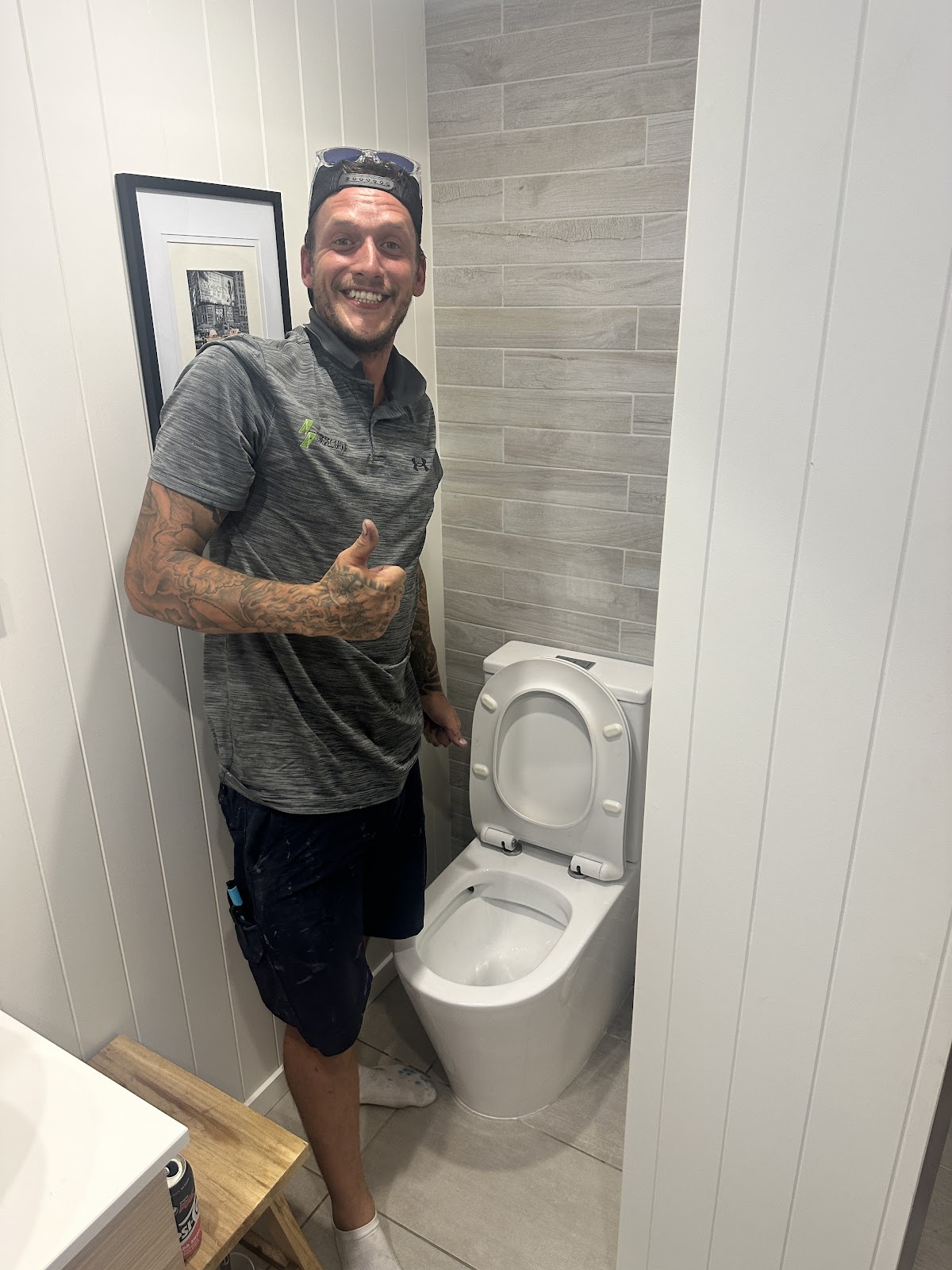 One of the Conspec crew giving a thumbs up beside a newly installed toilet